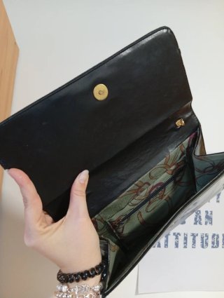Bolso de mano negro con detalle dorado