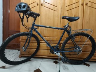 Bicicleta azul con casco, luz y candado