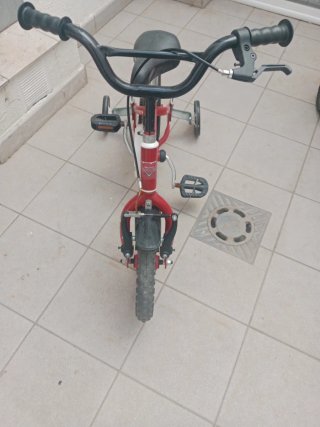 Bicicleta infantil roja con ruedines