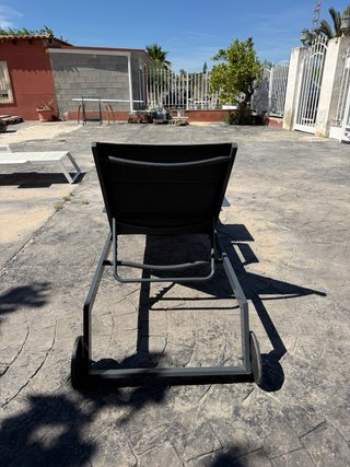 Tumbona de exterior gris con mesita