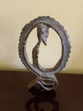 Figura de hombre serpiente arrodillado en bronce.