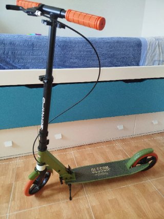 Patinete verde con ruedas naranjas