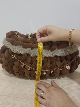 Borsa clutch marrone con dettagli oro.