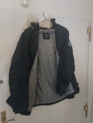 Abrigo acolchado negro con capucha y borde de pelo