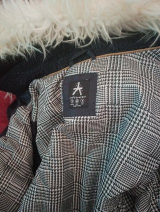 Abrigo acolchado negro con capucha y borde de pelo
