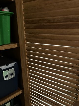 Armario de madera con puertas de lamas