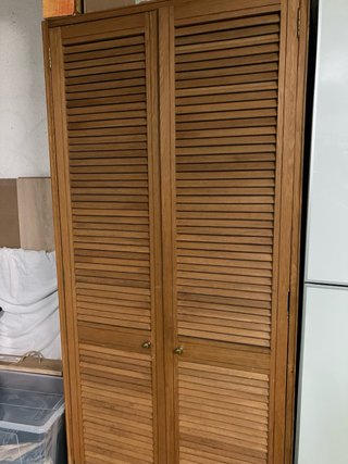 Armario de madera con puertas de lamas