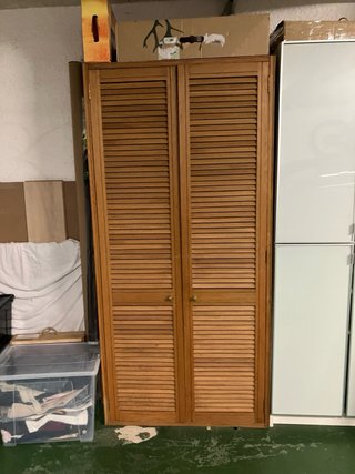 Armario de madera con puertas de lamas