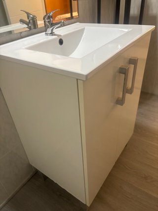Mueble de baño blanco con lavabo y grifo