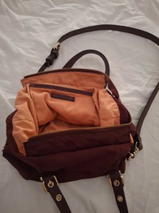 Bolso color burdeos, se puede usar de mano y bando