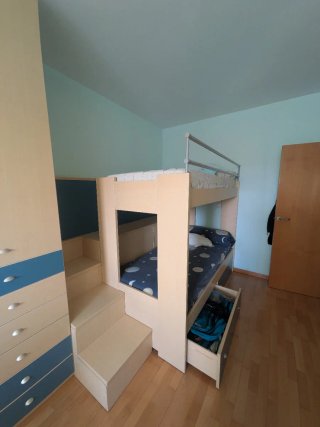 Litera de madera con escaleras y arcón