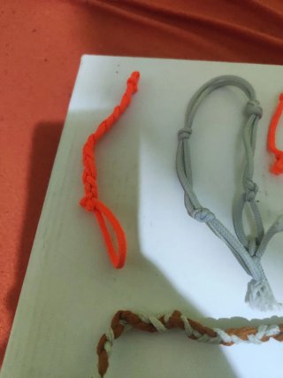 Pulseras tejidas grises y naranjas