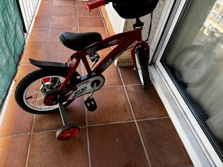 Bicicleta infantil roja con ruedines
