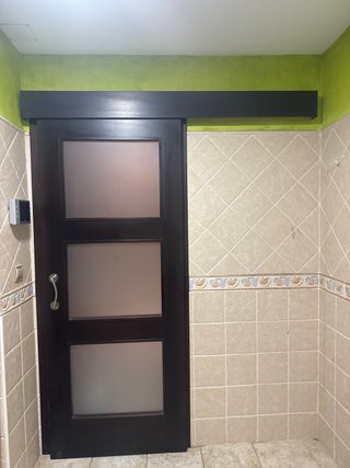Puerta corredera oscura con 3 paneles