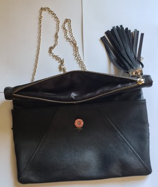 Bolso clutch negro con cadena dorada y borla