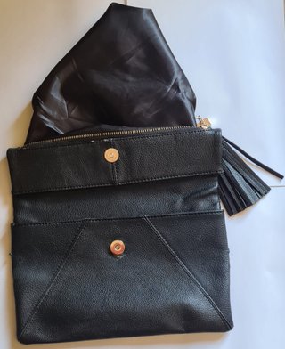Bolso clutch negro con cadena dorada y borla