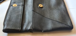 Bolso clutch negro con cadena dorada y borla