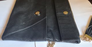 Bolso clutch negro con cadena dorada y borla