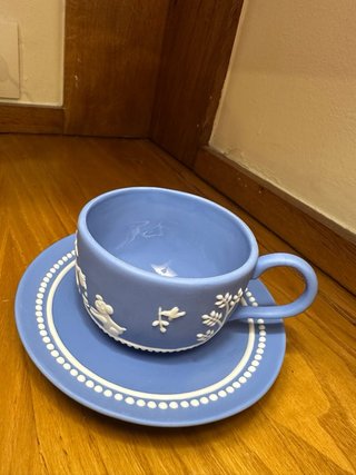 Taza y platillo azul de cerámica.