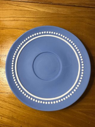 Taza y platillo azul de cerámica.