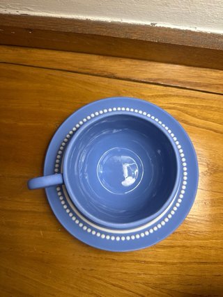 Taza y platillo azul de cerámica.