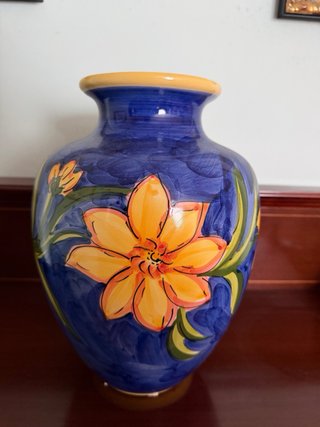 Jarrón de cerámica azul con flores naranjas