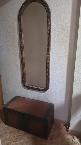 Espejo ovalado con baúl de madera y cuero