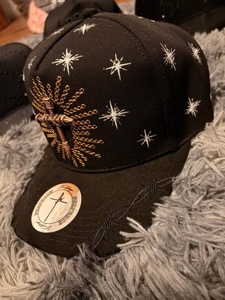 Gorra negra con estrellas y cruz dorada