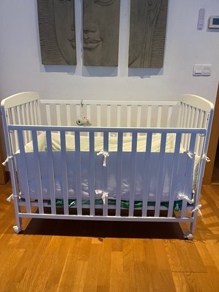 Cuna blanca con protector y ropa de cama