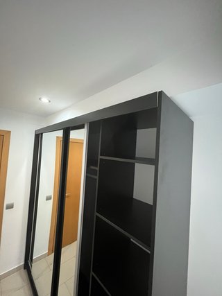 Armario de tres puertas correderas con espejo.