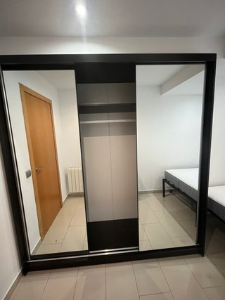 Armario de tres puertas correderas con espejo.