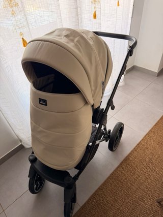 Carro de bebé con funda impermeable con maxicosi