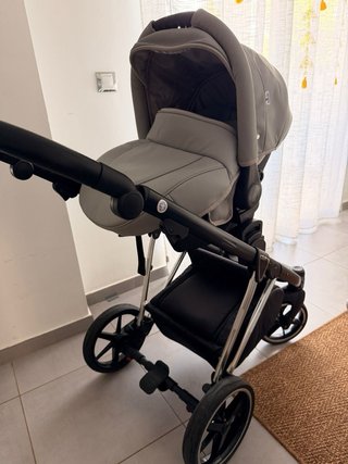 Carro de bebé con funda impermeable con maxicosi