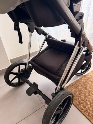 Carro de bebé con funda impermeable con maxicosi