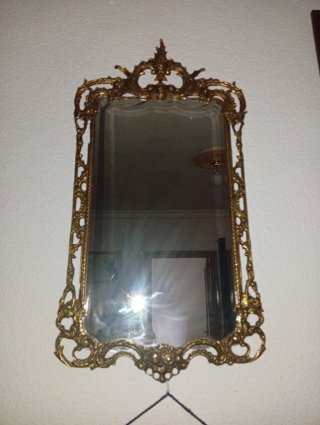 Espejo de bronce con marco ornamentado
