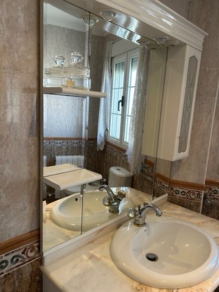 Mueble baño mármol curvo lavabo y espejo