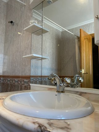 Mueble baño mármol curvo lavabo y espejo