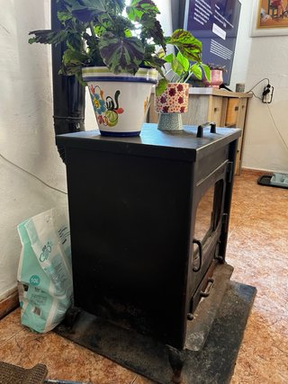 Estufa de leña negra con puerta de cristal