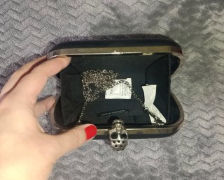 Bolso de mano negro con cierre de calavera