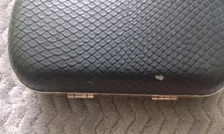 Bolso de mano negro con cierre de calavera