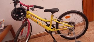 Bicicleta infantil amarilla con casco semi nueva
