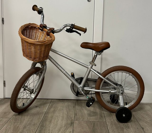 Bicicleta infantil plateada con cesta