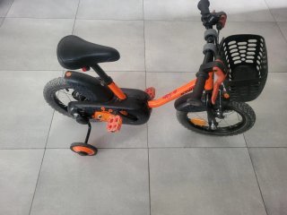 Bicicleta infantil naranja con ruedines