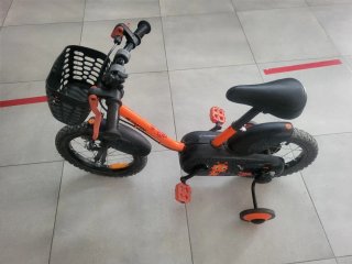 Bicicleta infantil naranja con ruedines