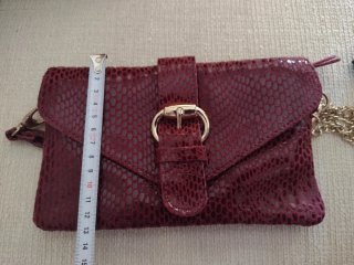 Bolso de mano de piel burdeos con cadena dorada