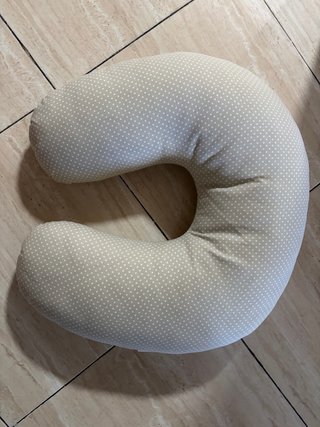Cojín de lactancia beige con lunares.