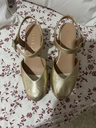 Zapatos Unisa dorados destalonados.