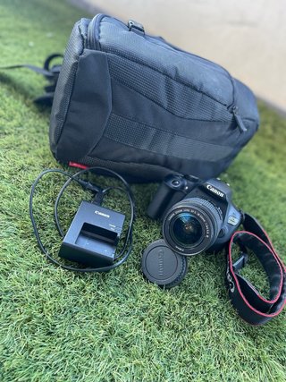 Cámara Canon EOS con objetivo y cargador