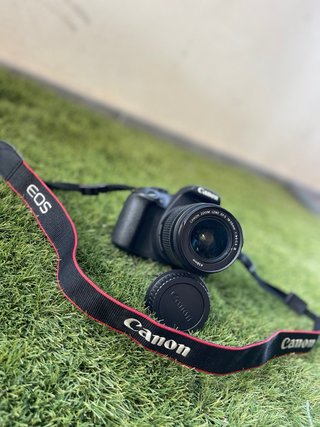 Cámara Canon EOS con objetivo y cargador