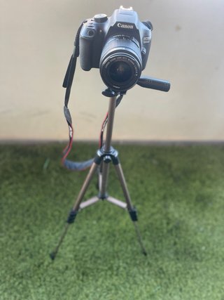 Cámara Canon EOS con objetivo y cargador